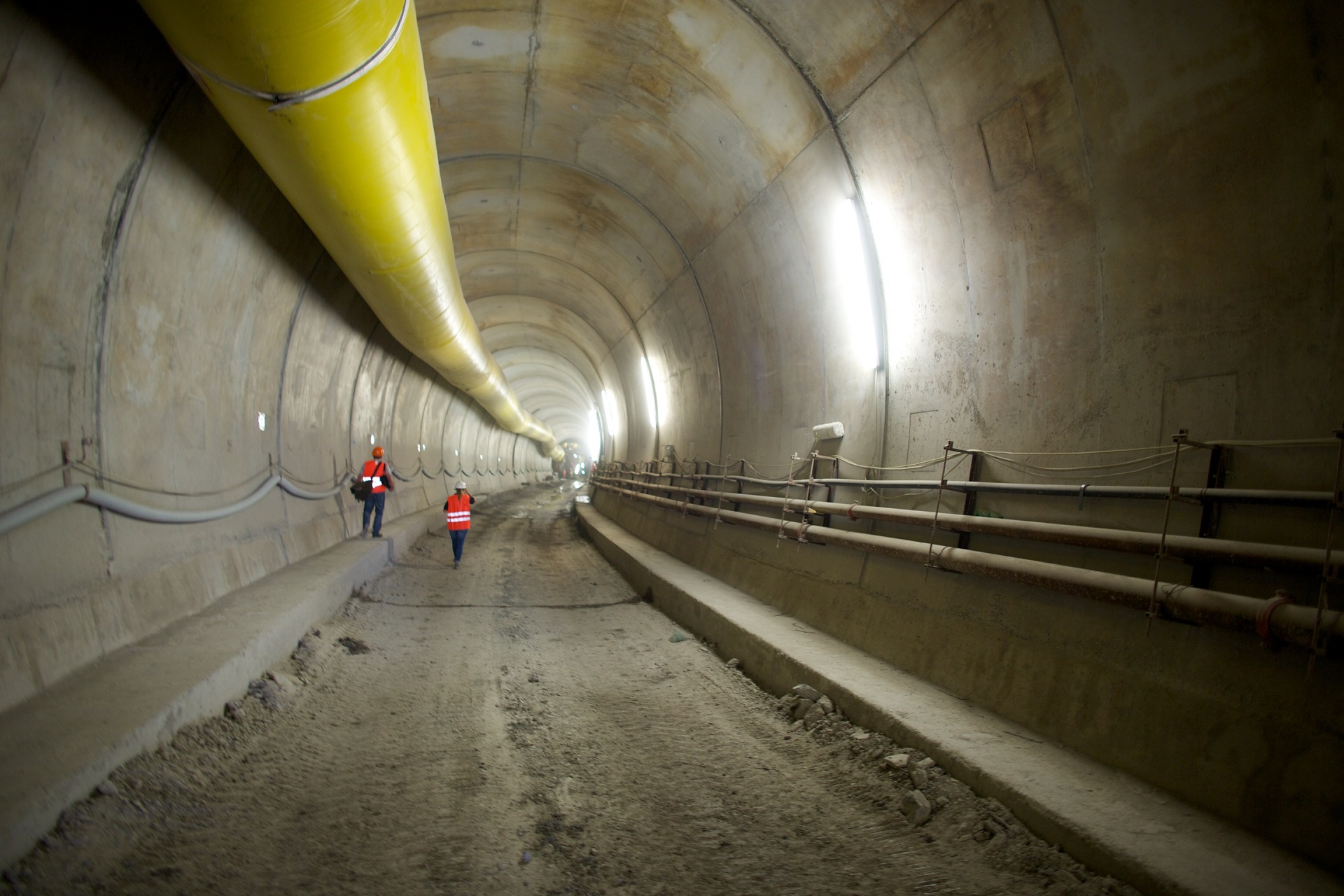Engineers inspecting underground tunnel construction with ventilation system, supporting environmental infrastructure and engineering services in Europe